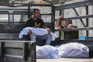 Палестинец c телом ребенка, погибшего во время авиаудара по Газе. 12 октября 2023 года