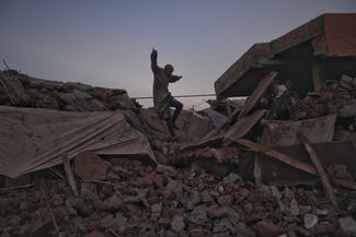 Мужчина пробирается сквозь завалы в поселке Талат-Ньякуб провинции Аль-Хауз, которая пострадала от землетрясения в Марокко сильнее всего