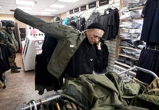 Житель Донецка примеряет куртку в военторге «Спецконтора»
