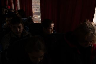Дети ожидают отъезда автобуса в ходе эвакуации из Херсона 30 октября 2023 года. В последнее время ракетные удары по городу участились — и многие семьи приняли решение временно вывезти своих детей в более безопасные регионы 