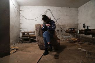 Женщина с кошкой в укрытии во время российского обстрела в Мариуполе. 24 февраля 2022 года