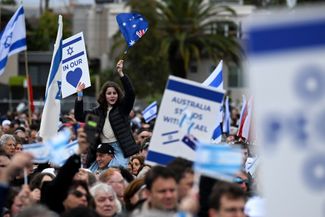 Жители австралийского Мельбурна собрались, чтобы почтить память израильтян, погибших во время атаки ХАМАС. На их плакатах — надписи «Австралия поддерживает Израиль» и «Израиль в наших сердцах». 13 октября 2023 года