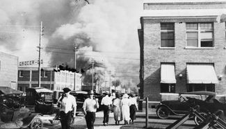 Вооруженные белые участники погромов идут по горящему району компактного проживания чернокожих Гринвуд. Талса, штат Оклахома, 1 июня 1921 года