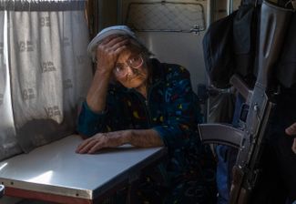 Военный проходит мимо пожилой женщины в эвакуационном поезде, который ожидает отправления из зоны боевых действий в Покровске, городе на северо-западе Донецкой области. На прошлой неделе Покровск подвергался обстрелам