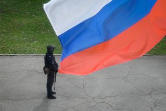Полицейский под российским флагом в Луганске