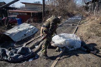 Украинский военный и тела российских солдат. Ирпень, 10 марта 2022 года