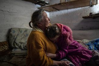 10-летняя Христина и ее бабушка, 70-летняя Любовь, укрываются в подвале дома во время обстрела, 9 апреля 2023 года
