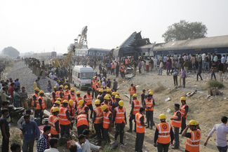 Спасатели на месте крушения пассажирского поезда на севере Индии. 20 ноября 2016 года