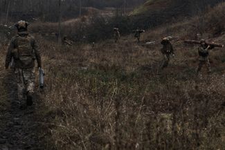 Украинские солдаты несут бревна для строительства блиндажа