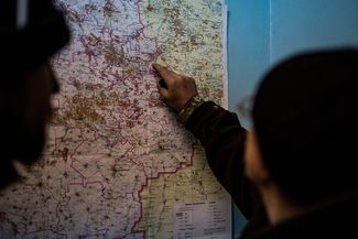 Ukrainian soldiers stand by a map of the Donetsk region discussing the tactical situation around Debaltsevo.