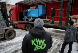 Работники зоопарка разгружают генераторы для обогрева вольеров, которые им передал Берлинский зоопарк