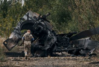 Украинский солдат у подбитого российского танка на дороге к Балаклее