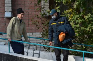 Сотрудник российского МЧС сопровождает пожилого мужчину