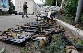 Separatist fighter walks past weapons seized from a Ukrainian military base in Donetsk, June 27, 2014