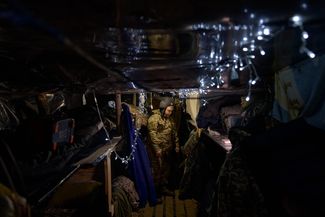 Украинский военный с позывным Бодя украшает окоп к Новому году.