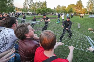 Protesters pull down a fence surrounding the construction site of St. Catherine’s Cathedral in Yekaterinburg, May 13, 2019