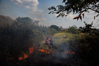 Жители деревни в провинции Цзянси пытаются потушить горящую траву. 25 августа 2022 года