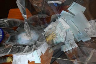 Members of a local election committee in Vladivostok emptying a ballot box during the last day in the constitutional plebiscite on July 1, 2020 