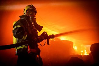 Пожарный у горящих складов в Одессе