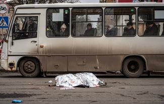 Жители Донецка смотрят на тело женщины, <a href="https://t.me/tass_agency/232607" rel="noopener noreferrer" target="_blank">погибшей</a> во время обстрела. Еще три человека были ранены