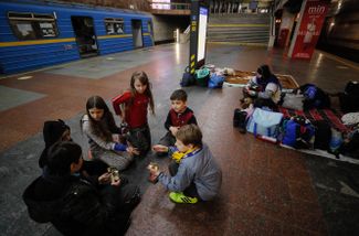 Children play in a subway station in Kyiv while an air-raid siren sounds