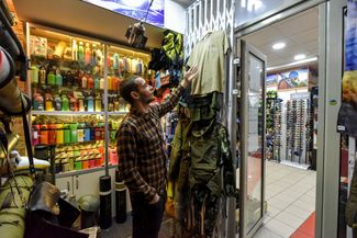 Продавец показывает российскую военную форму