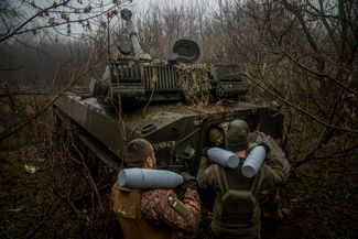 Украинские артиллеристы из 24-й бригады загружают боеприпасы в самоходную гаубицу 2С1 «Гвоздика» на позиции вдоль линии фронта в окрестностях Бахмута