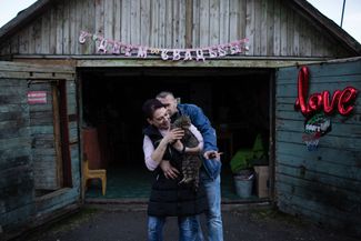 A local couple, Anna (who works as a vendor) and Sergey (a miner), celebrate their wedding outside their garage.