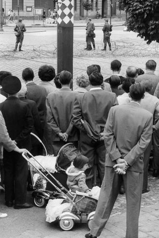 Жители Западного Берлина наблюдают за началом строительства стены, которая разделила их город почти на 30 лет
