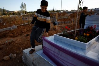 12-летний Салих, сын Эмруллы, и его девятилетний двоюродный брат Явуз, сын Али, бегают среди могил
