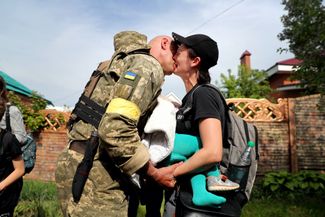 Женщина с ребенком на руках, эвакуированная из города Купянск со своим партнером, военнослужащим ВСУ. Купянск оккупирован российскими войсками.