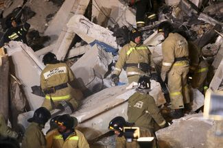 Rescue workers sift through debris after the explosion. December 31, 2018.