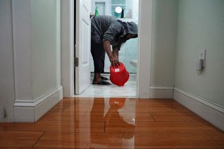Житель Бруклина вычерпывает воду из своей квартиры