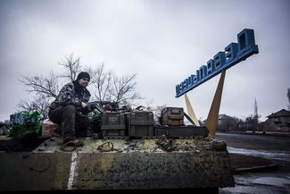 A Ukrainian soldier is seen atop of a Ukrainian armored vehicle while resupplying their battalion at the gate of Debaltseve, 3 February, 2015.