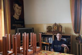 A young drug addict in Yekaterinburg sits in a room decorated with a poster of Evgeny Roizman on August 31, 2007