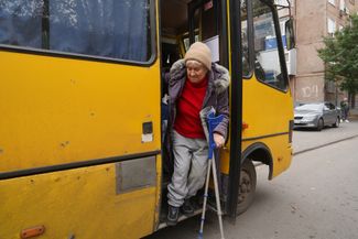 Жительница Купянска выходит из автобуса, на котором ее эвакуировали в Харьков. 17 октября 2024 года