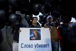 Участники акции памяти погибших в Донбассе держат плакат с изображением Джен Псаки. Москва, 27 сентября, 2014 г.