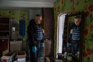 Судебно-медицинский эксперт полиции осматривает дом, где во время оккупации Вишневой жили российские военные