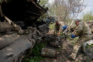 Украинские военные ремонтируют танк.
