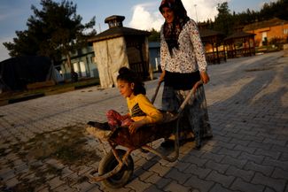 Asli, 33, Emrulla's wife, plays with her nine-year-old daughter Zuleikha