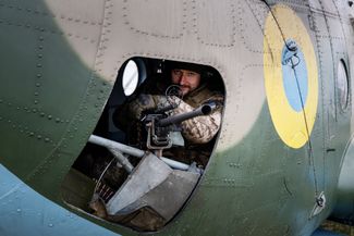 Украинский военнослужащий 12-й авиационной бригады в боевом вертолете Ми-8