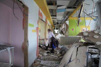 Медик в коридоре мариупольского роддома, поврежденного в результате обстрела. 9 марта 2022 года