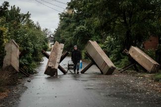 Житель Бахмута идет мимо противотанковых ежей. Город, несмотря на атаки российских вооруженных сил, остается под контролем Украины