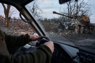 Ukrainian soldiers drive by a destroyed artillery installation on the road to Avdiivka. February 14, 2024. 