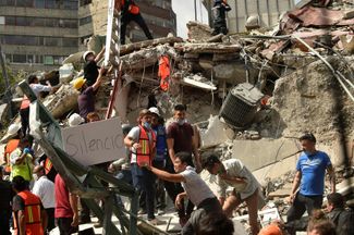 Спасатели устраивают «минуту тишины», чтобы услышать голоса тех, кто мог оказаться под завалами. Мехико, 19 сентября