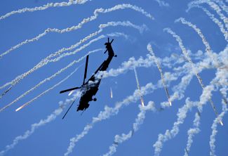 Вертолет Ми-28 выполняет фигуры высшего пилотажа и отстреливает тепловые ловушки, призванные обмануть зенитные ракеты. В войне с Украиной документально подтверждены потери от огня ПВО семи вертолетов этого типа