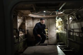 Работник танкоремонтной мастерской собирается выходить из украинского БТР 
