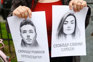 Акция в поддержку Романа Протасевича и Софьи Сапеги в Вильнюсе в мае 2021 года. Участница акции держит в руках их портреты