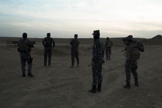 Сотрудники федеральной полиции Ирака на территории сельскохозяйственного колледжа в Хаммам аль-Али в окрестностях Мосула. На территории колледжа были обнаружены более 200 тел жертв, казненных боевиками ИГ перед отступлением