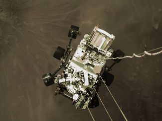 Марсоход «Персеверанс» во время посадки. Это кадр из видео, снятого с камеры, установленной на посадочном модуле.